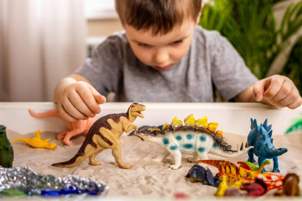 istock Confident cute baby boy playing carnivorous and herbivorous dinosaurs early development game 1387572769