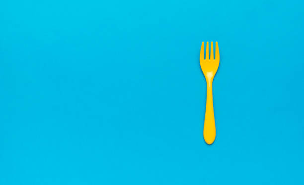 istock Beautiful plastic yellow fork on a blue background. Space for text. Flat lay. 1387572796