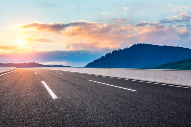 istock Asphalt road and mountain with clouds at sunrise 1387574481