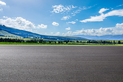 Empty asphalt road and green mountain nature scenery under blue sky. Road and mountains background.