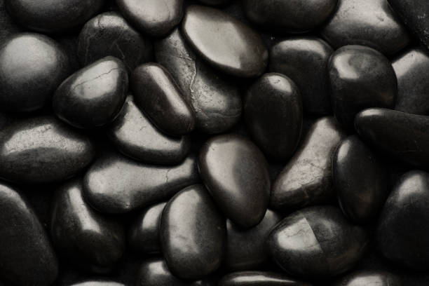 istock Black natural stones covered in rain drops showing textures and patterns formed 1387578363