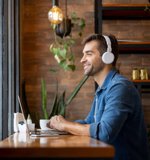 istock Happy man working on his laptop at a coffee shop 1387578780