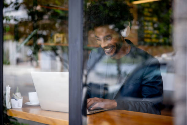 istock Happy business man working on his laptop at a cafe 1387578799