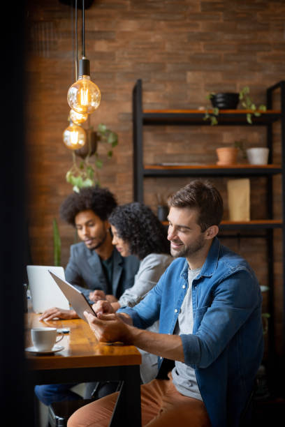 istock Brazilian man working online at a cafe using a tablet 1387578816