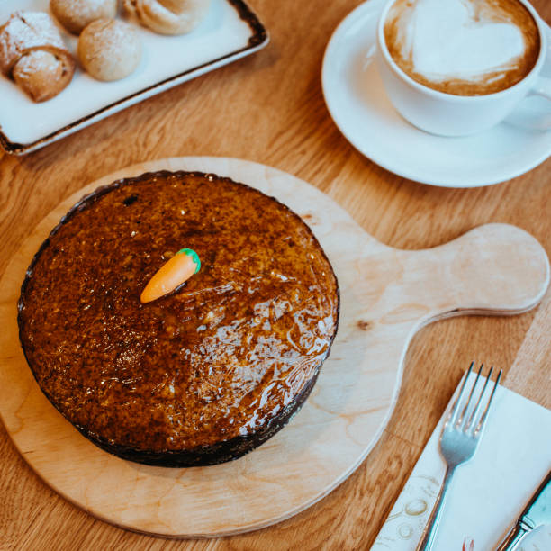 Coffee with freshly baked carrot cake and cookies, studio shot cake on wooden background, carrot cake stock photo, circle shaped cake