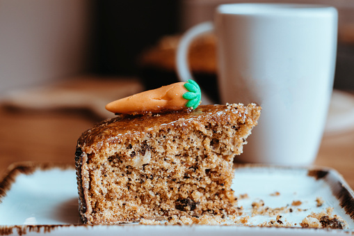 Freshly baked carrot cake slice, coffee cup on defocus background, carrot cake stock photo, slice cake