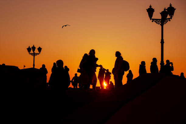 Silhouette of group of people against the sunset on embankment. Sevastopol. Crimea stock photo
