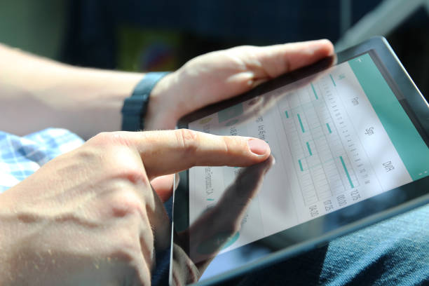 Truck driver checking electronic logbooks on a tablet stock photo