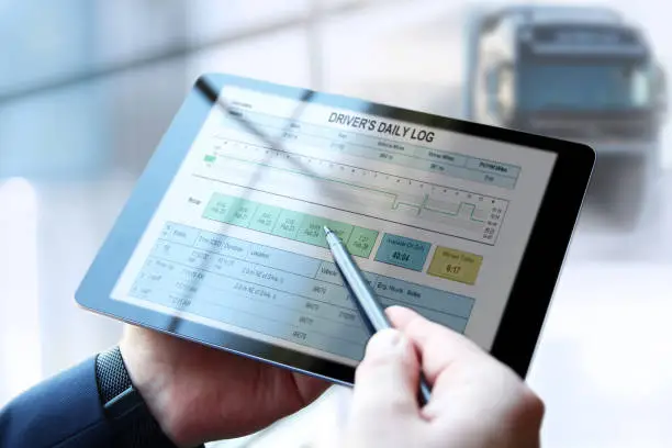 Photo of Safety manager is showing to Truck driver the electronic logbooks on a tablet