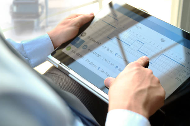 Safety manager is showing to Truck driver the electronic logbooks on a tablet stock photo
