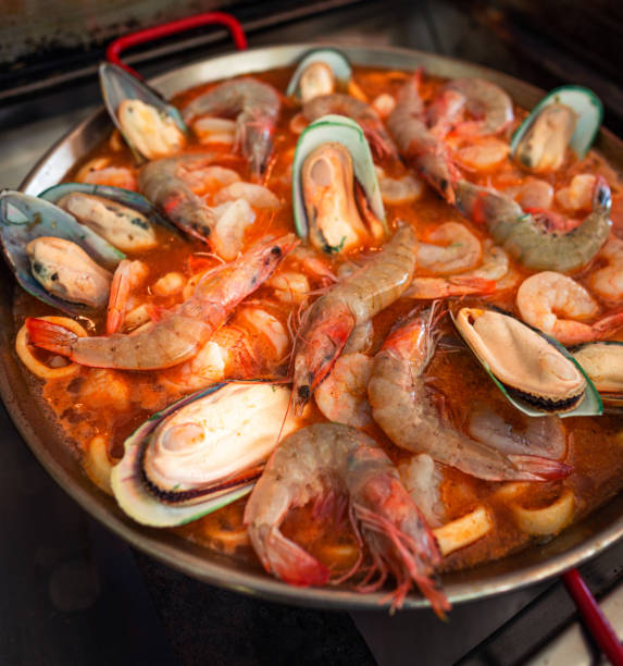 paella spagnola con abbondanza di frutti di mare - seafood lobster paella prepared shellfish foto e immagini stock