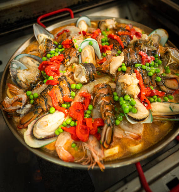 paella espagnole aux fruits de mer - seafood lobster paella prepared shellfish photos et images de collection