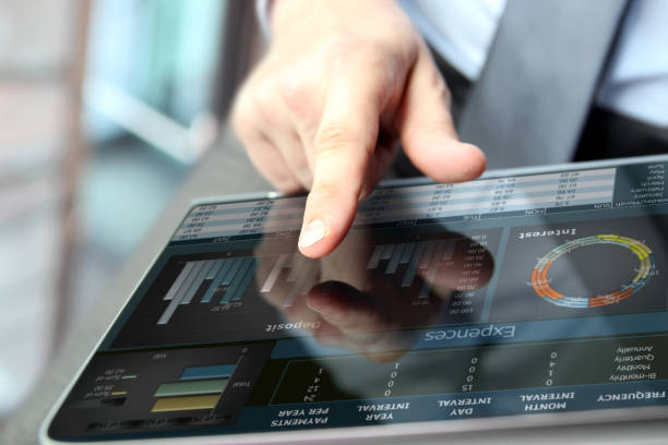 istock Business man working and analyzing financial figures on a graphs on a tablet 1387589000