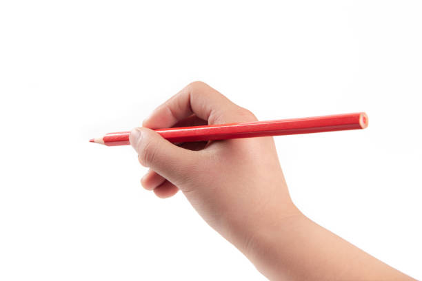istock Kid hand holding pencil, writing or drawing, isolated on white background. 1387589808