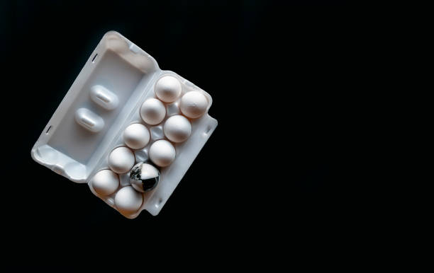 istock Fresh chicken eggs closeup on a black background. marble stone egg on a background of white chicken eggs 1387590009