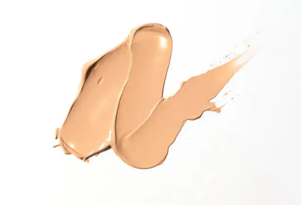 Creamy foundation smeared on white background. Isolated. Beauty and fashion conception. Liquid cream cosmetic, smudge texture