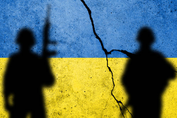 Flag of Ukraine painted on a concrete wall with soldiers stock photo