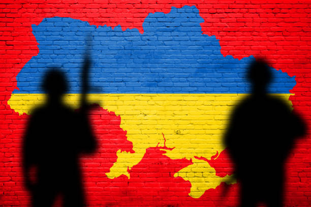 istock Flag of Ukraine painted on a concrete wall with soldiers 1387595708