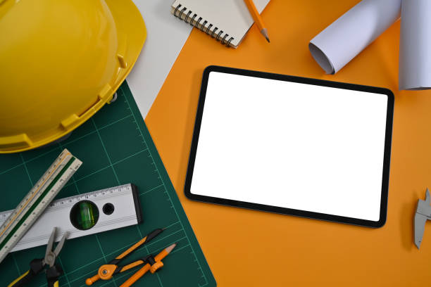 istock Above view digital talet, helmet, blueprints and mechanical tools on Architect workplace. 1387596016