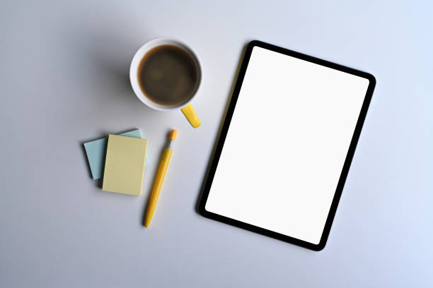 istock Mockup digital tablet, coffee cup and sticky notes on office desk. Top view. 1387596038