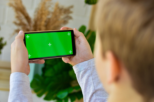 Smartphone with a green screen in hand child.