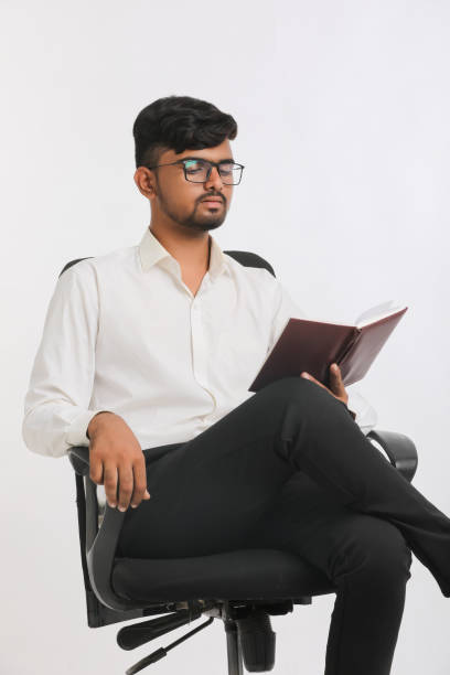 giovane maschio indiano che legge diario su sfondo bianco. - young adult engineer intelligence male beauty foto e immagini stock
