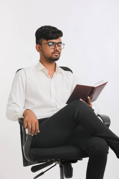 istock Young Indian male reading Diary over white background. 1387603452