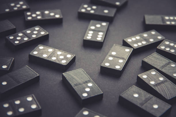 istock Black dominoes on dark table background 1387604411