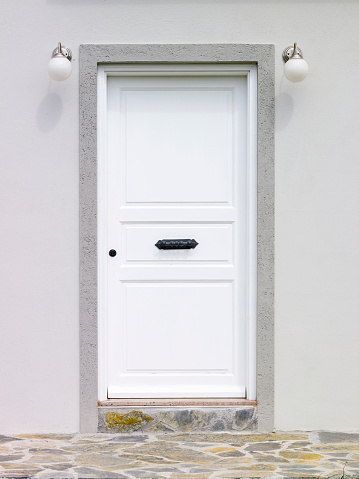 Modern white front door on a new residential house with a beautiful clinker facade
