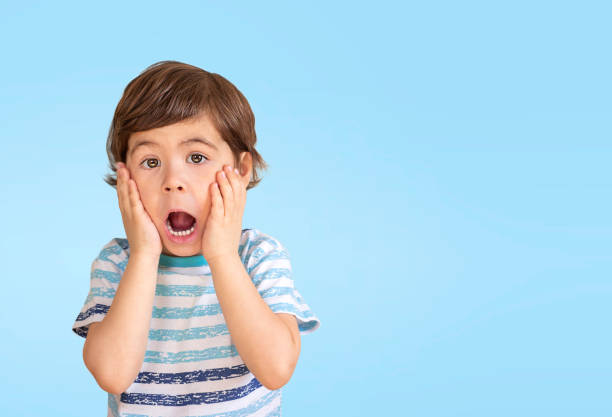 istock portrait of a little boy on a blue background 1387606777