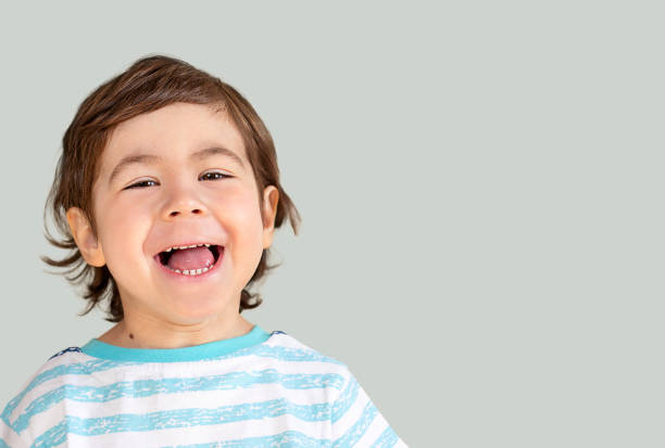 istock little smiling boy on a gray background 1387606919
