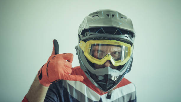 istock Man wearing a motocross enduro helmet on white background 1387608034