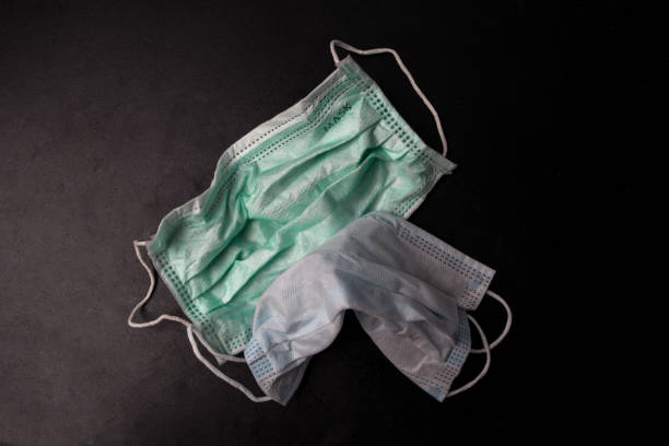 istock used mask isolated on a black background. Infectious waste. 1387609097