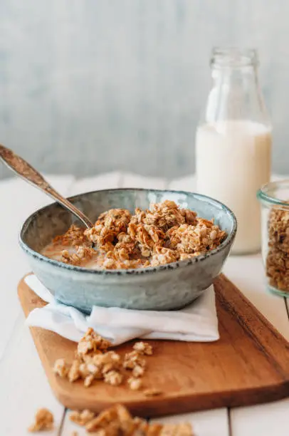 Nut granola in a bowl standing on a cutting board