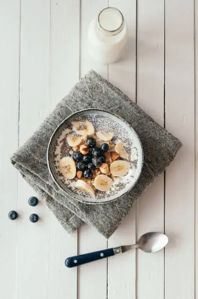 Granola with blueberries and hazelnuts in a bowl standing on a tea towel