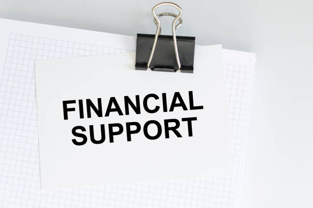 istock Paper with text FINANCIAL SUPPORT on a table with a notepad on a clip, a business concept 1387614147