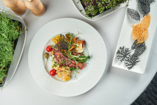 istock Grilled octopus with vegetables on a white plate on a white tablecloth 1387614171