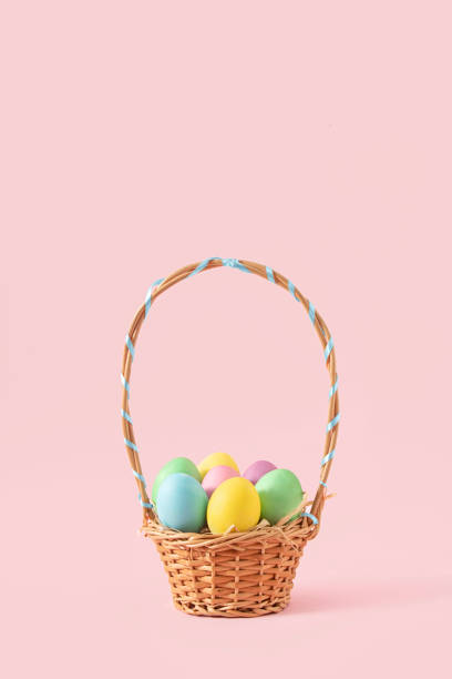 istock Creative concept of an Easter basket full of pastel colored eggs. Minimal Spring decoration on pink background. 1387614281
