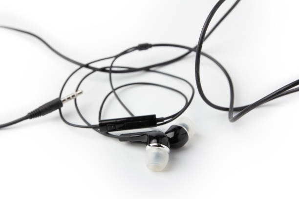 istock tangled black headphones isolated on a white background. 1387614313