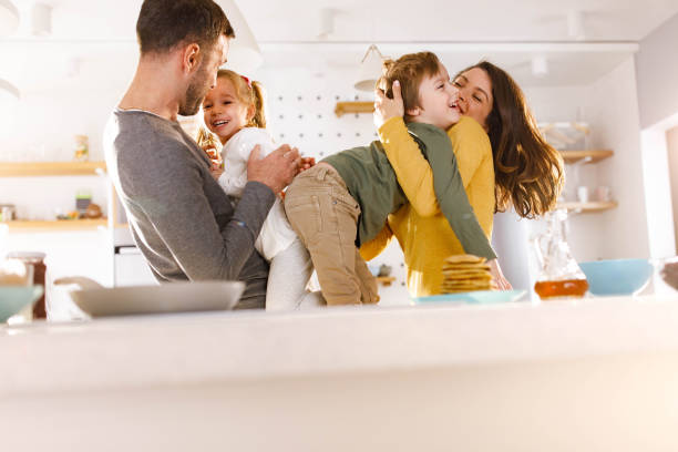 istock Happy parents having fun with their kids in dining room. 1387615432