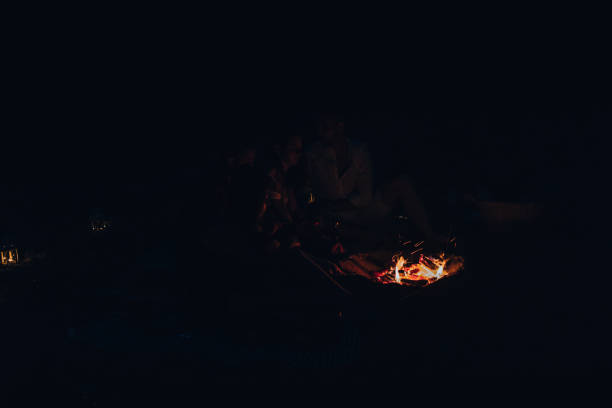 istock People sit at night round a bright bonfire on the beach 1387619286