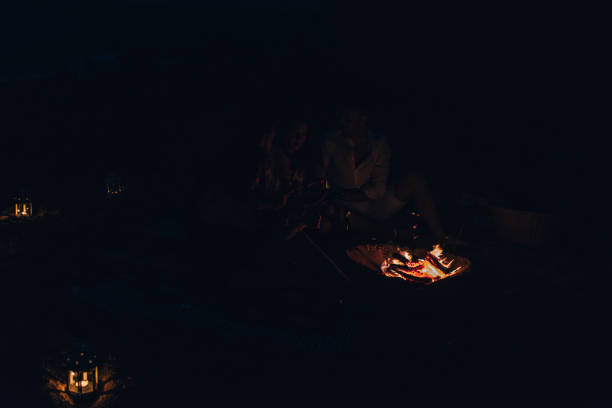 istock Friends enjoying music near campfire at night 1387619603
