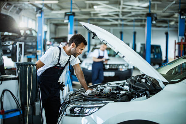 mecânico automático que analisa problemas do motor ao trabalhar em uma oficina. - oficina de automóvel - fotografias e filmes do acervo