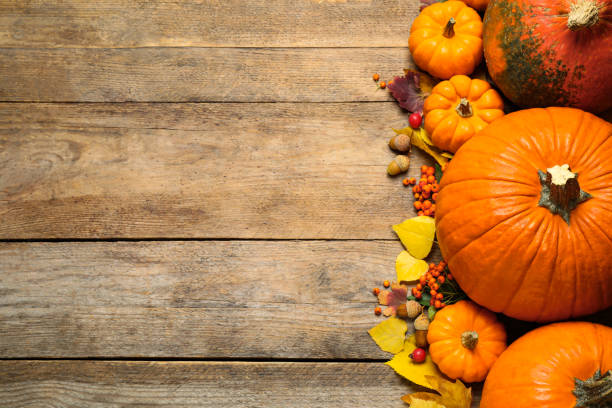 istock Flat lay composition with pumpkins and autumn leaves on wooden table. Space for text 1387620865