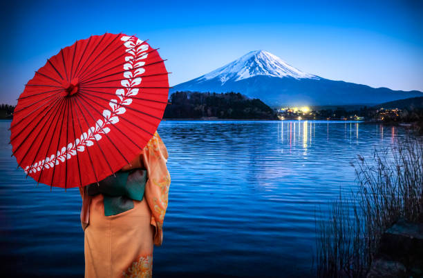 geisha avec parapluie rouge devant le mont fuji la nuit reflétée sur le lac kawaguchi, japon - lake kawaguchi photos et images de collection