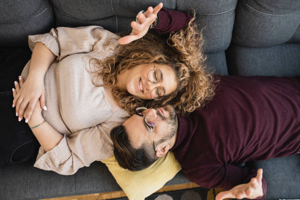 istock Happy couple enjoying their weekend day laying down on the sofa 1387621118