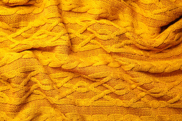 istock Soft orange knitted plaid as background, top view 1387621734