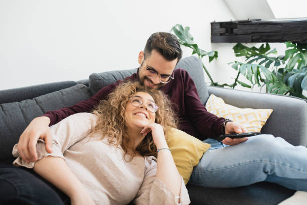 istock Happy couple relaxing on the sofa and watching TV 1387624034