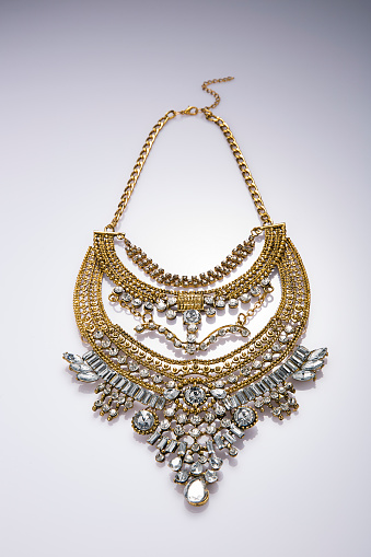 Fashionable gold necklace on white background