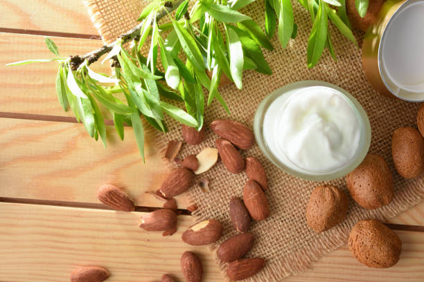 istock Moisturizing cream with almond extract on wooden table top view 1387626196